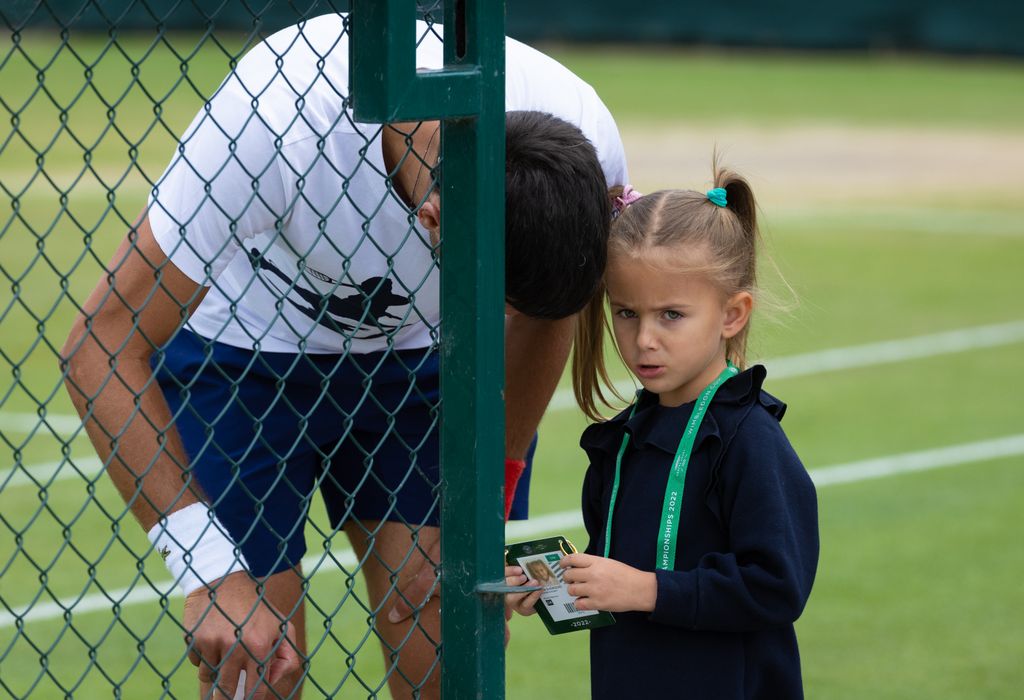 Novak Djokovic talking to his daughter Tara on a tennis court