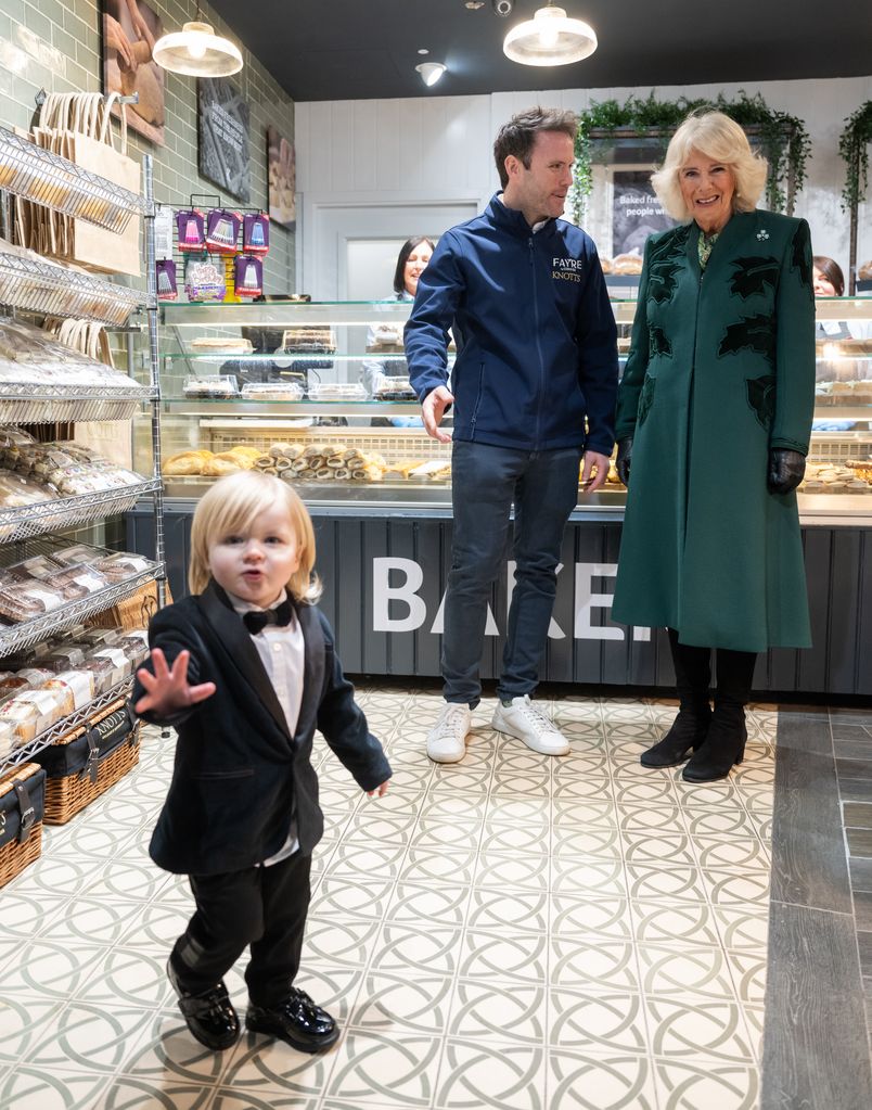 Queen Camilla looks on at one year old Fitz William Salmon-Corrie as she visits Knotts bakery in Belfast