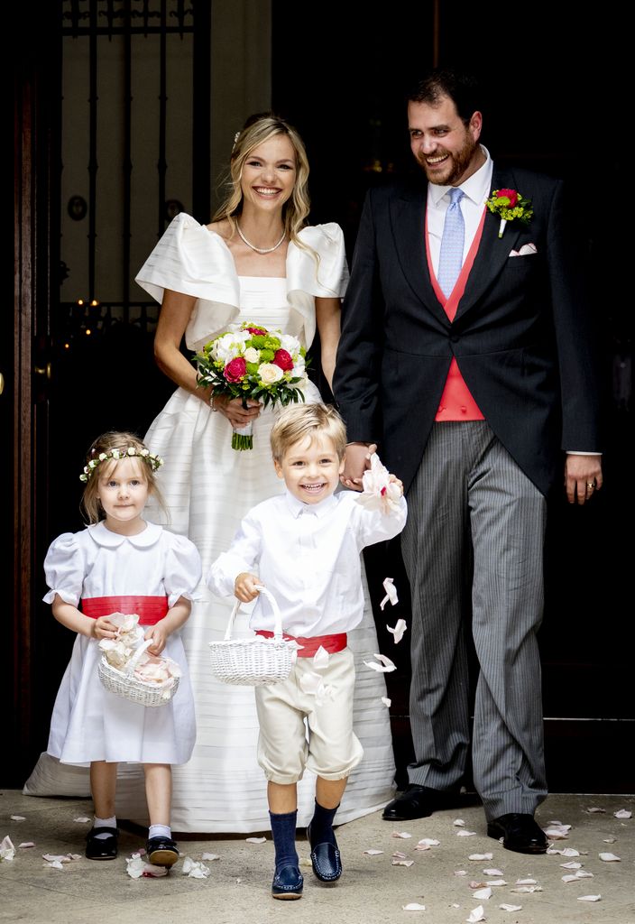 Prince Johann-Wenzel of Liechtenstein and Countess Felicitas of Hartig smiling for photos with their flower girl and page boy at their religious wedding