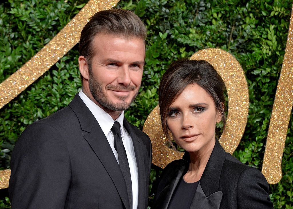 David Beckham and Victoria Beckham wearing black and smiling for the cameras at the British Fashion Awards 2015