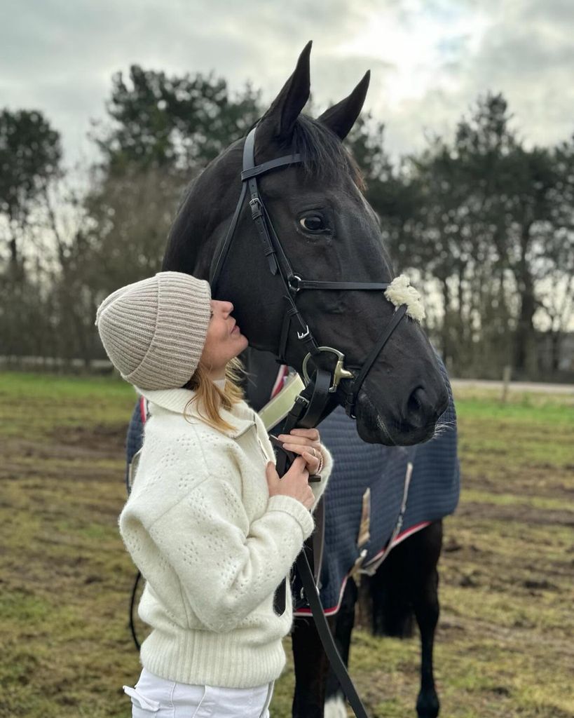 Geri Halliwell-Horner posing with pet horse in field