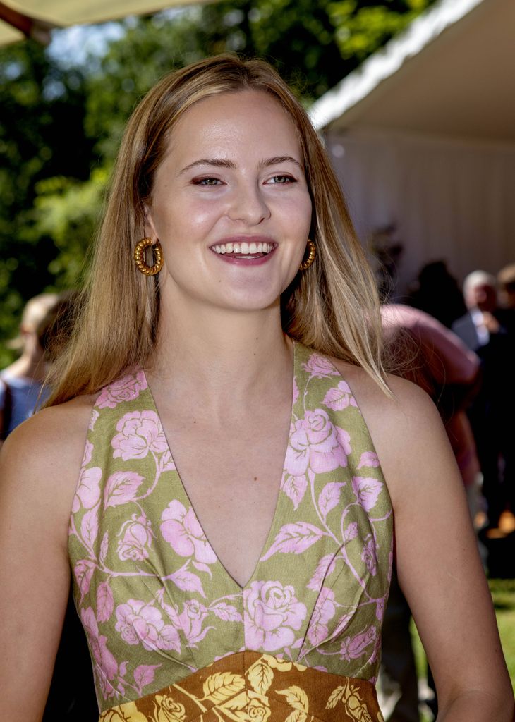 Princess Marie Caroline smiling in floral dress and hooped earrings