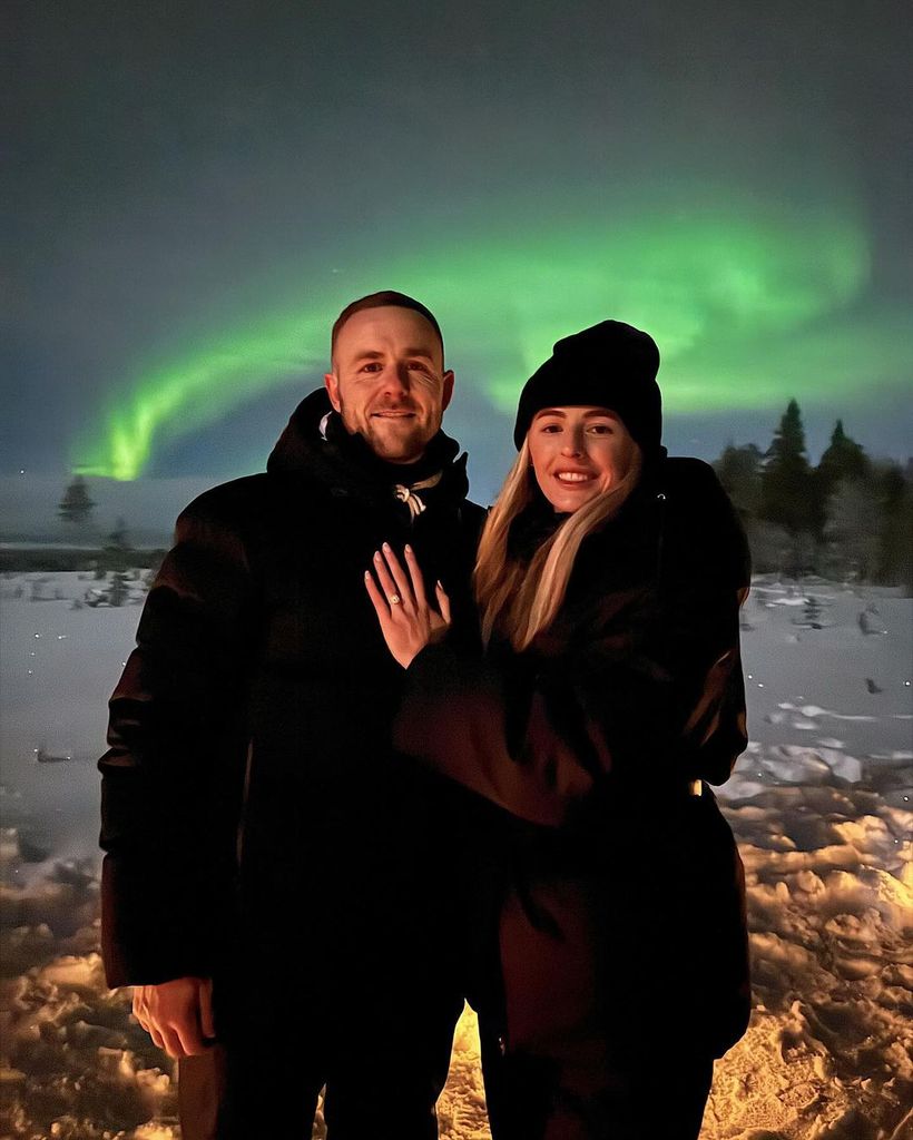 Chloe Kelly showing off her engagement ring in front of the northern lights