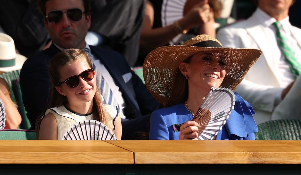 Charlotte and Kate smiling holding fans
