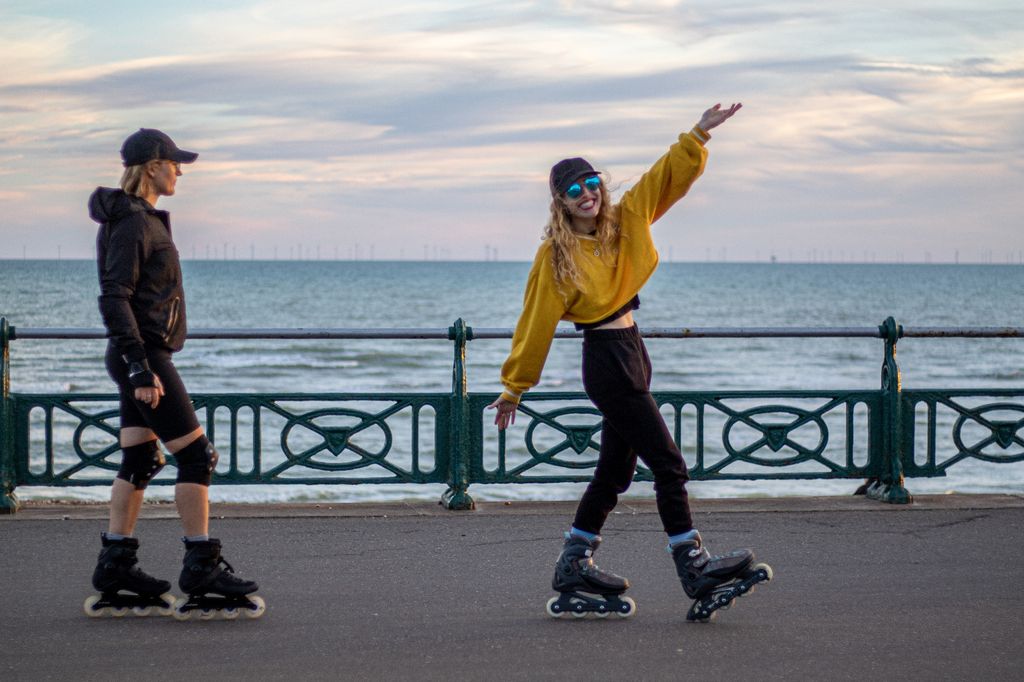 Woman rollerblading in a yellow hoodie in Brighton