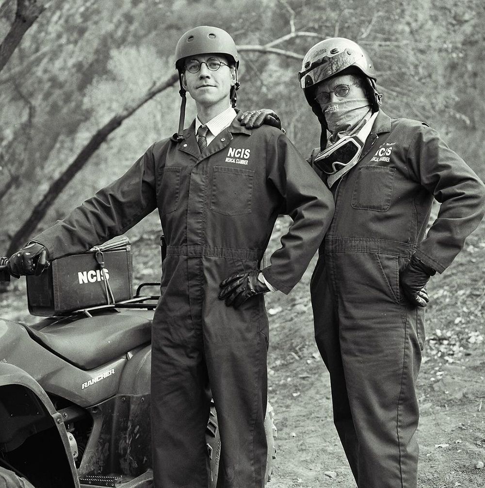 Brian Dietzen and David McCallum pose by a motorbike on the NCIS set 