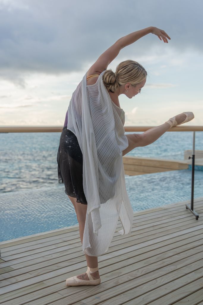 Woman doing ballet against a sea backdrop