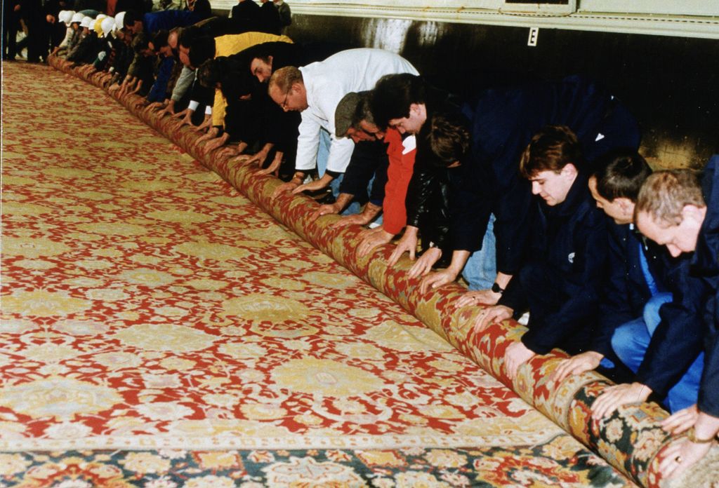 Workmen laying a carpet