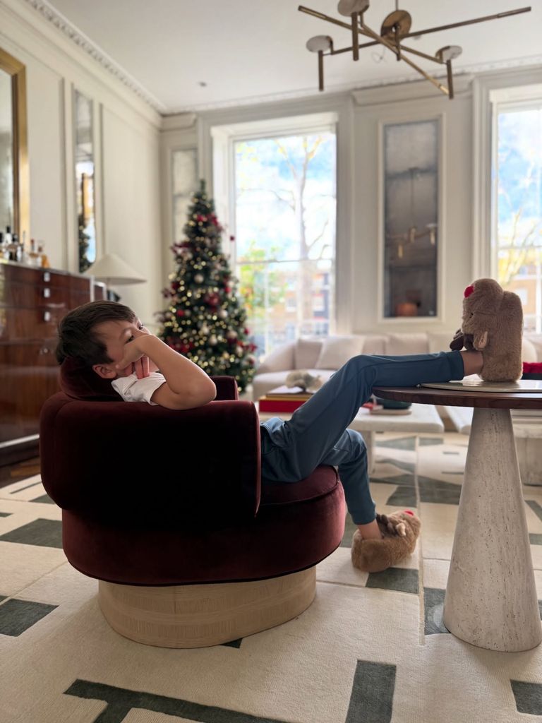 Wolfie sitting on red chair in living room which is light and airy