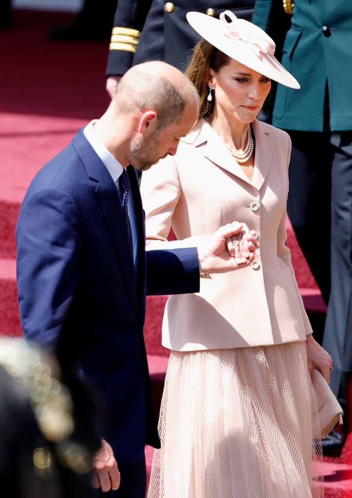 William holding Kate's hand down the steps