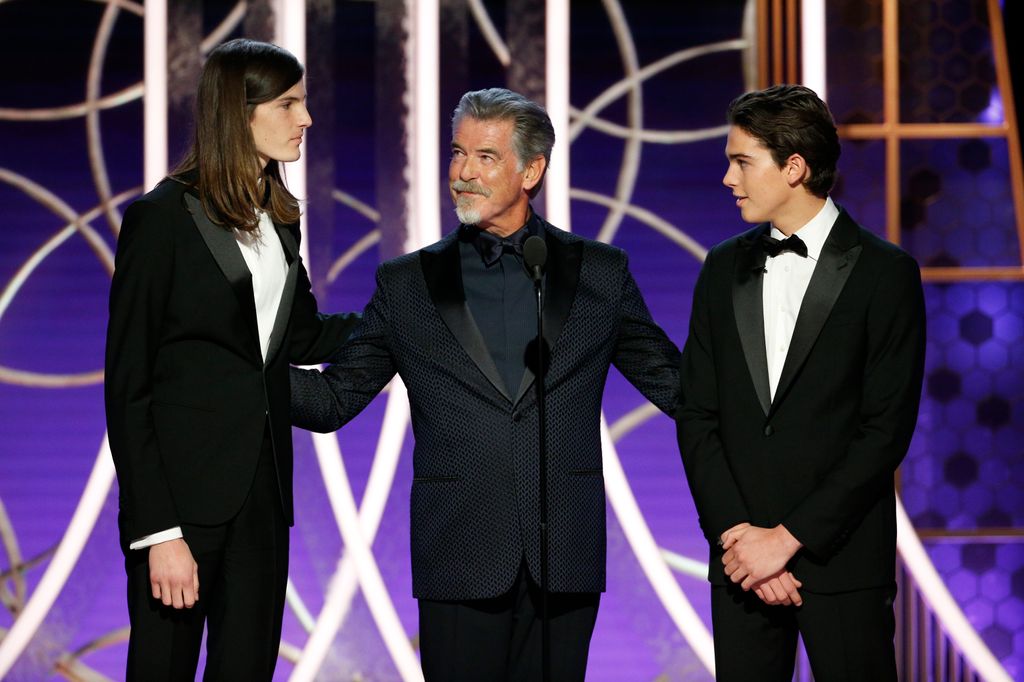 In this handout photo provided by NBCUniversal Media, LLC,  Golden Globe Ambassador Dylan Brosnan, father and actor Pierce Brosnan and Golden Globe Ambassador Paris Brosnan speak onstage during the 77th Annual Golden Globe Awards at The Beverly Hilton Hotel on January 5, 2020 in Beverly Hills, California