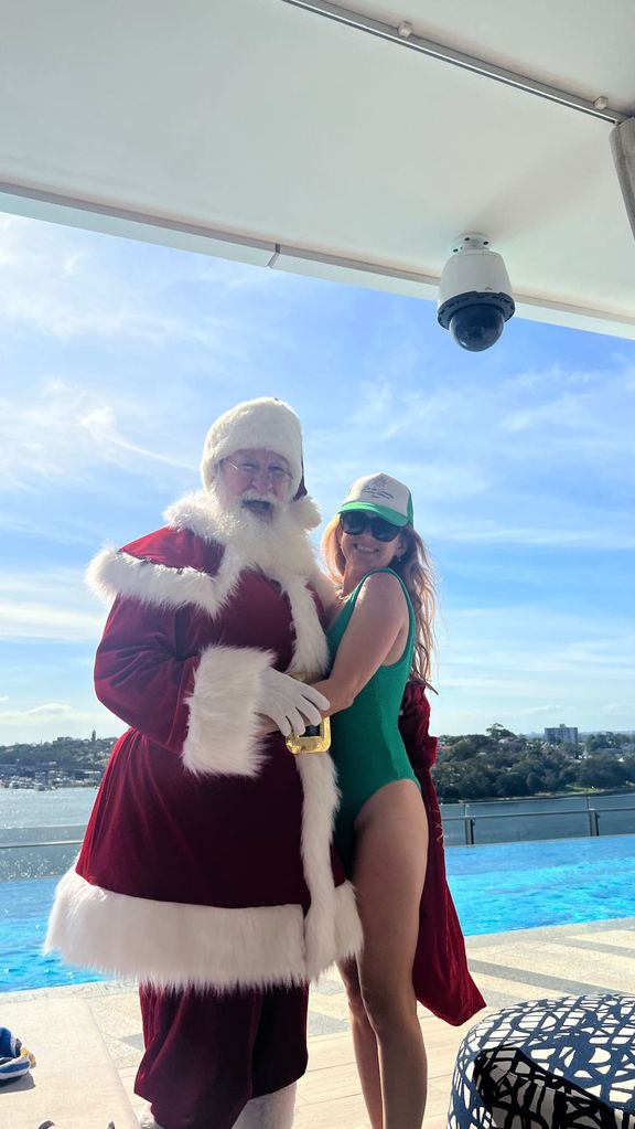 isla fisher in swimsuit posing with father christmas