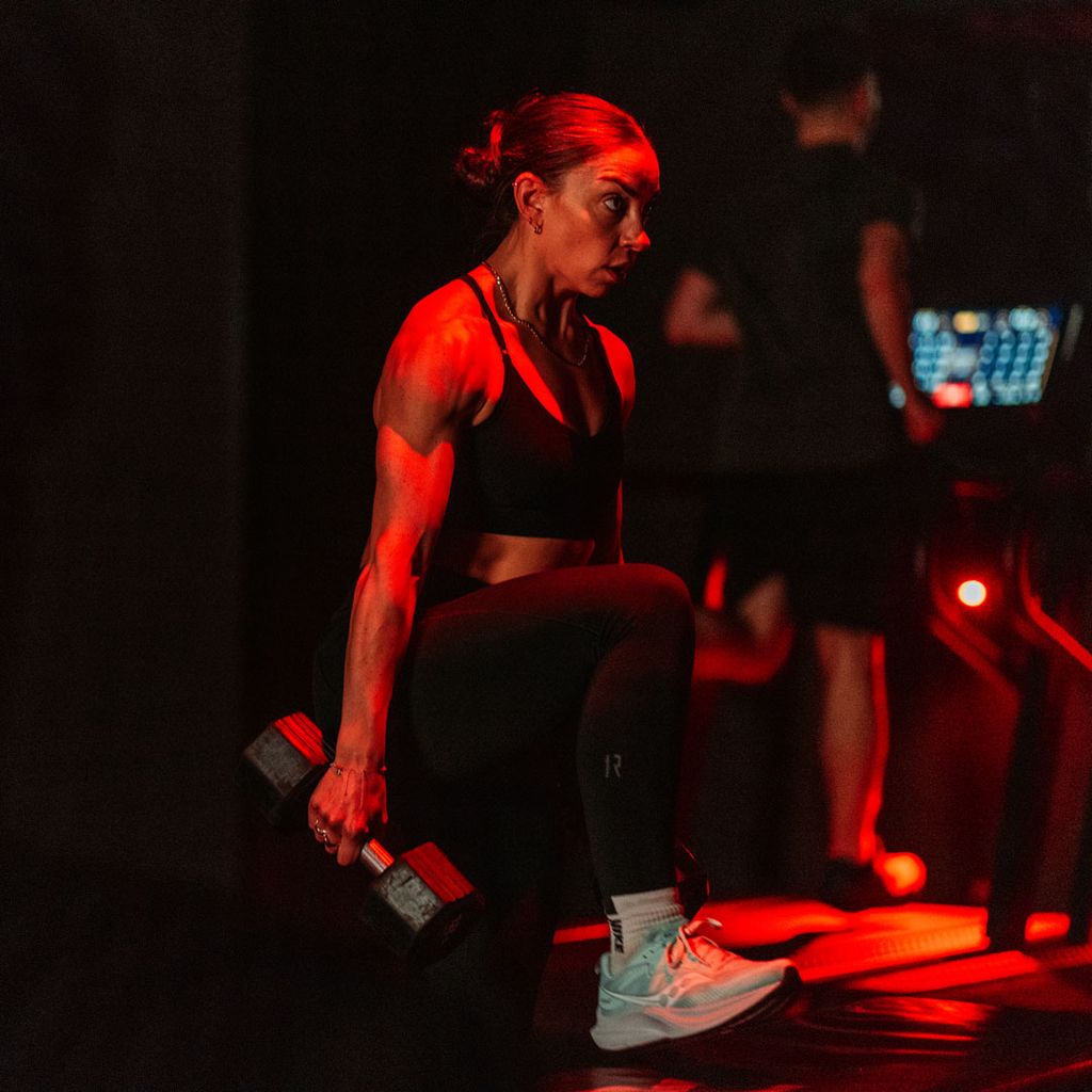 1Rebel Review: J'ai essayé la classe d'exercice qui ressemble à une boîte de nuit 2 Femme faisant des exercices de poids dans le gymnase