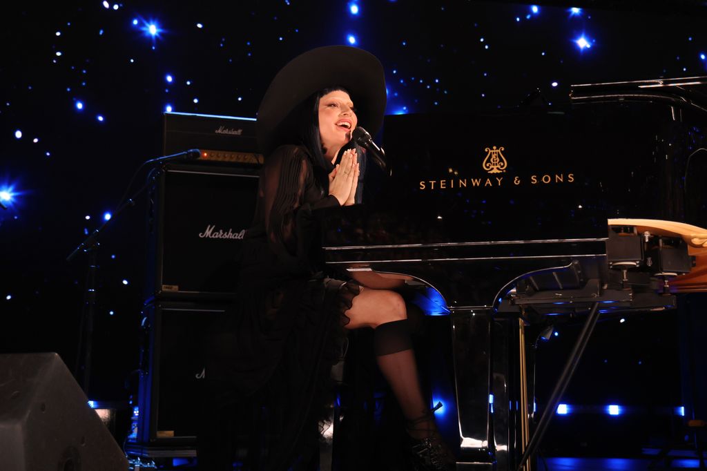 Lady Gaga Sitting in a Black Piano Fireid Concert