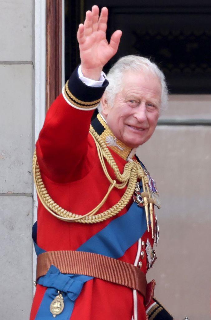 King Charles in ceremonial outfit waving at crowds