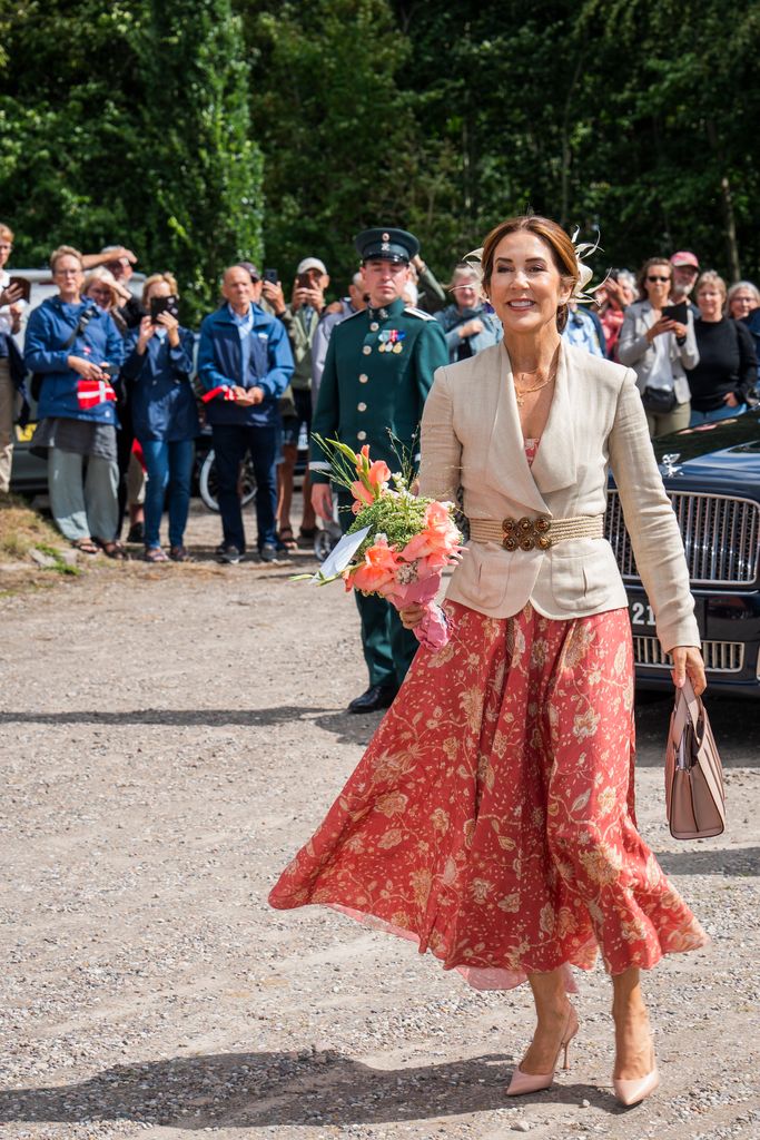 Queen Mary smiling holding flowers