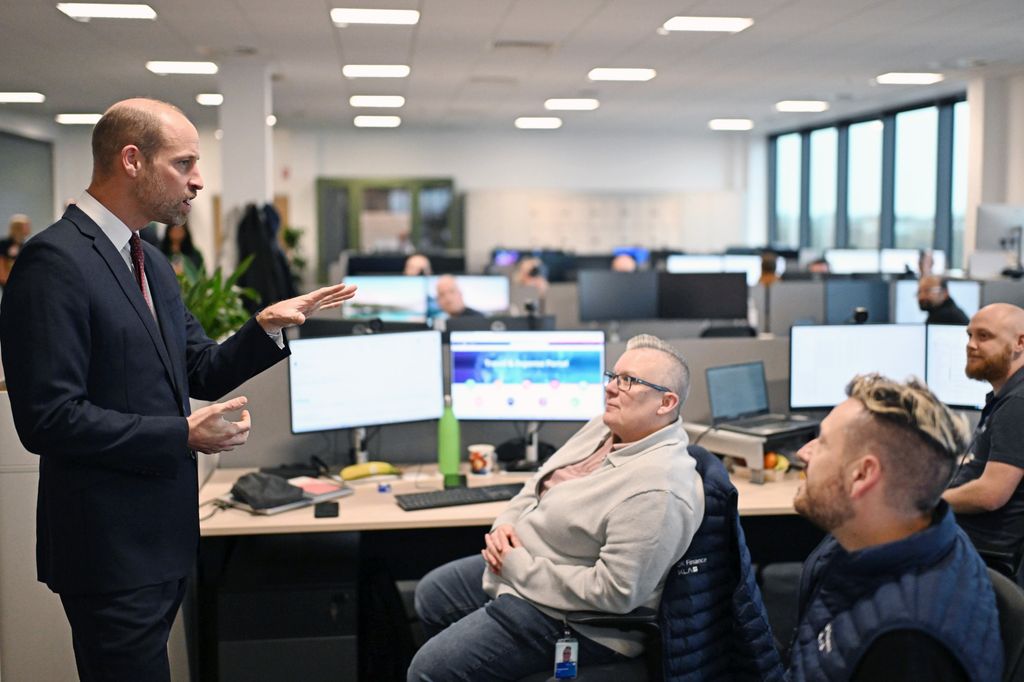 The Prince of Wales talks to employees in an office