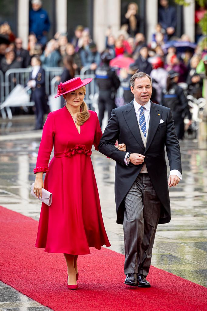 Grand Duchess Stephanie in ruby red walk up red carpet with husband