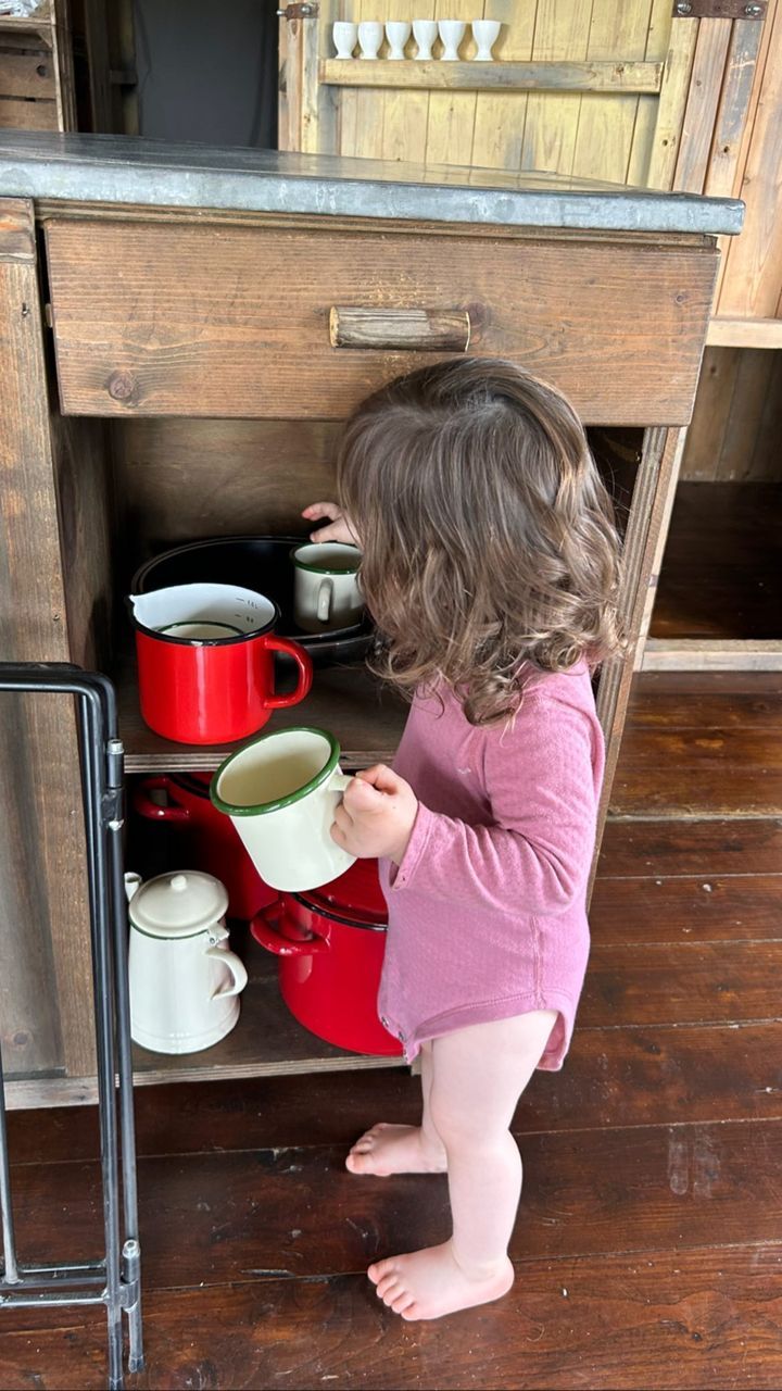 Annie inspecting mugs in kitchen 