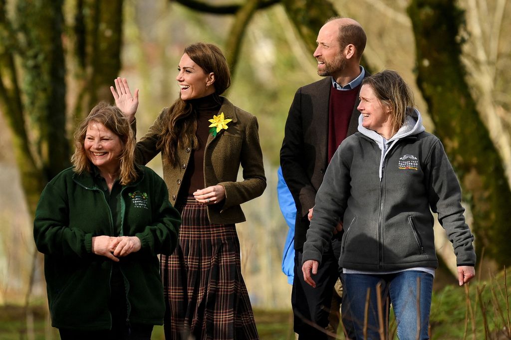 Catherine, princesse de Galles (2L) britannique et britannique, le prince William, le prince de Galles (2R) marche avec la directrice du développement communautaire Helen Williams et le bénévole Dawn Parker lors d'une visite au jardin communautaire de Meadow Street et à Woodland à Pontypridd, au sud du Pays de Galles,