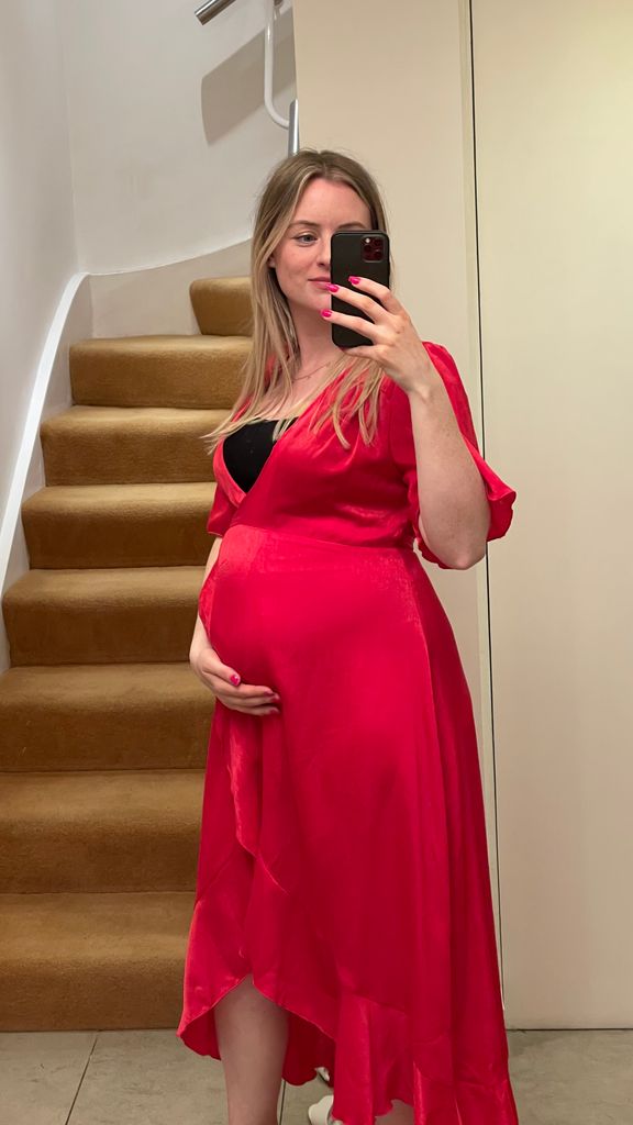 pregnant woman posing in a red dress