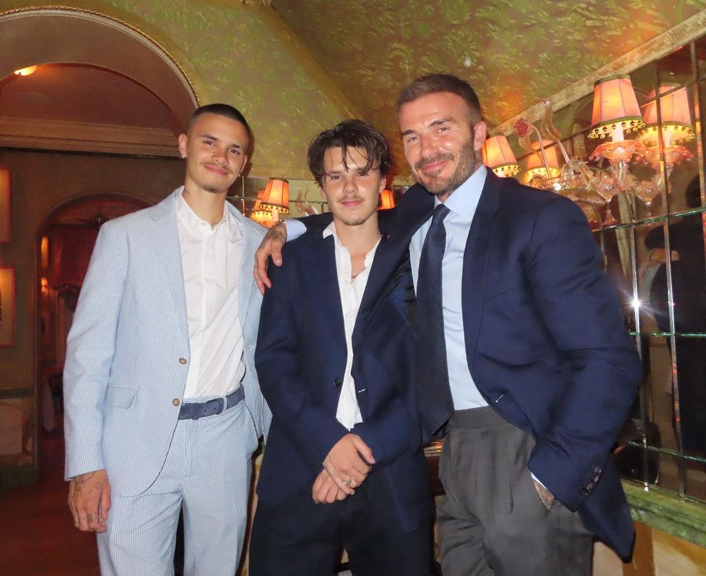 Romeo Cruz and David Beckham posing inside restaurant