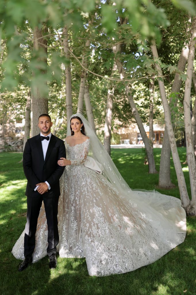 Celio Saab and Zein Qutami posing in a black tuzedo and a white wedding dress