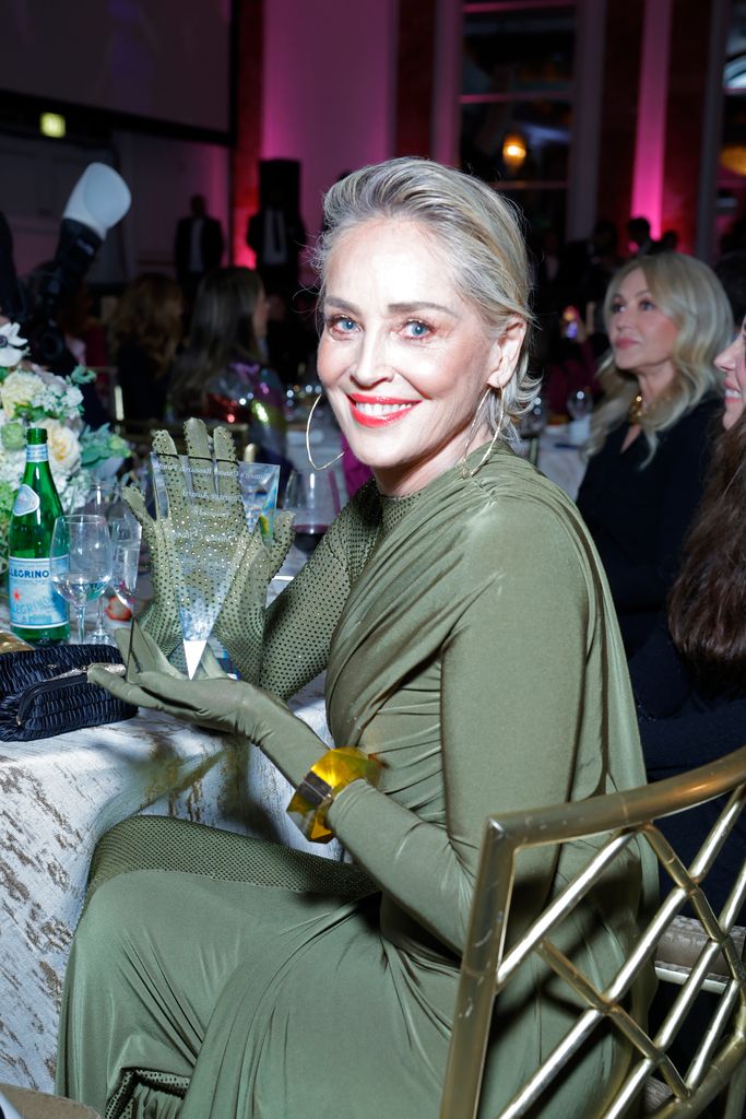 Sharon Stone in green holding an award
