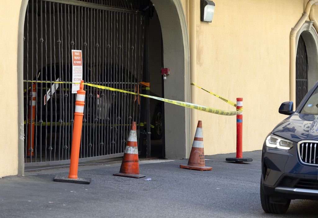 A damaged garage gate is blocked off. A tragic trail of violence began at this Woodland Hills apartment complex with dead and injured bodies scattered across Los Angeles County. Photographed at the Montecito Apartments in Woodland Hills, CA on Tuesday, April 9, 2024