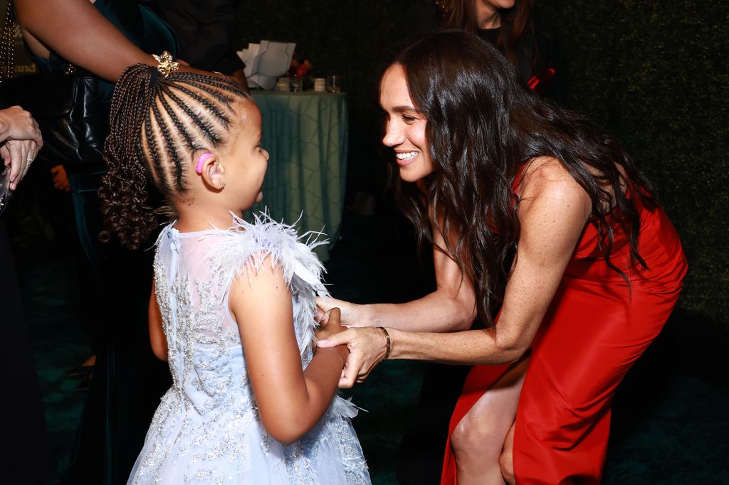 woman speaking to young girl at gala