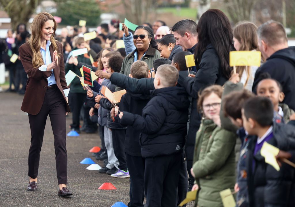 La princesse de Galles en costume marron dans la cour de récréation de l'école