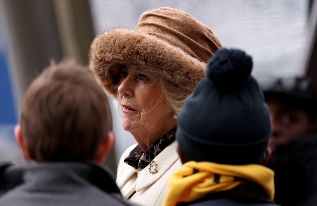 woman in fur hat and white coat outside 