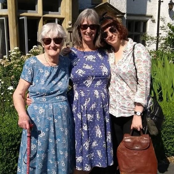 Three women standing in the sun smiling