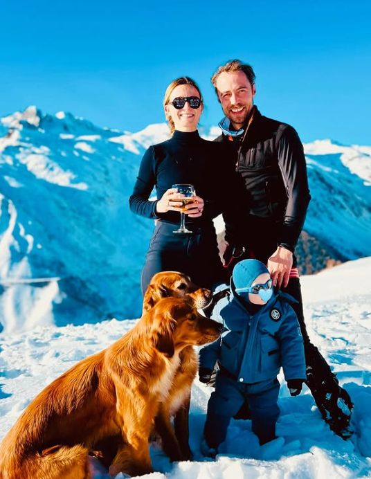 Alizee Thevenet and James Middleton in black outfits with a young boy in a blue outfit and two dogs