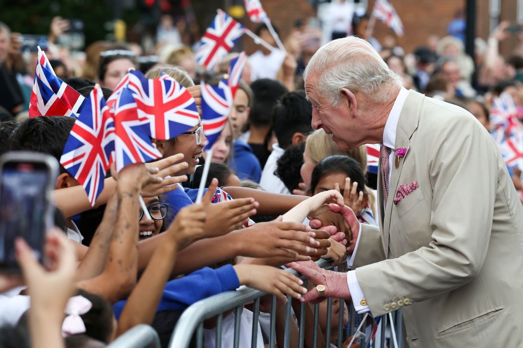 King Charles III (R) meets well-wishers during a walkabout 