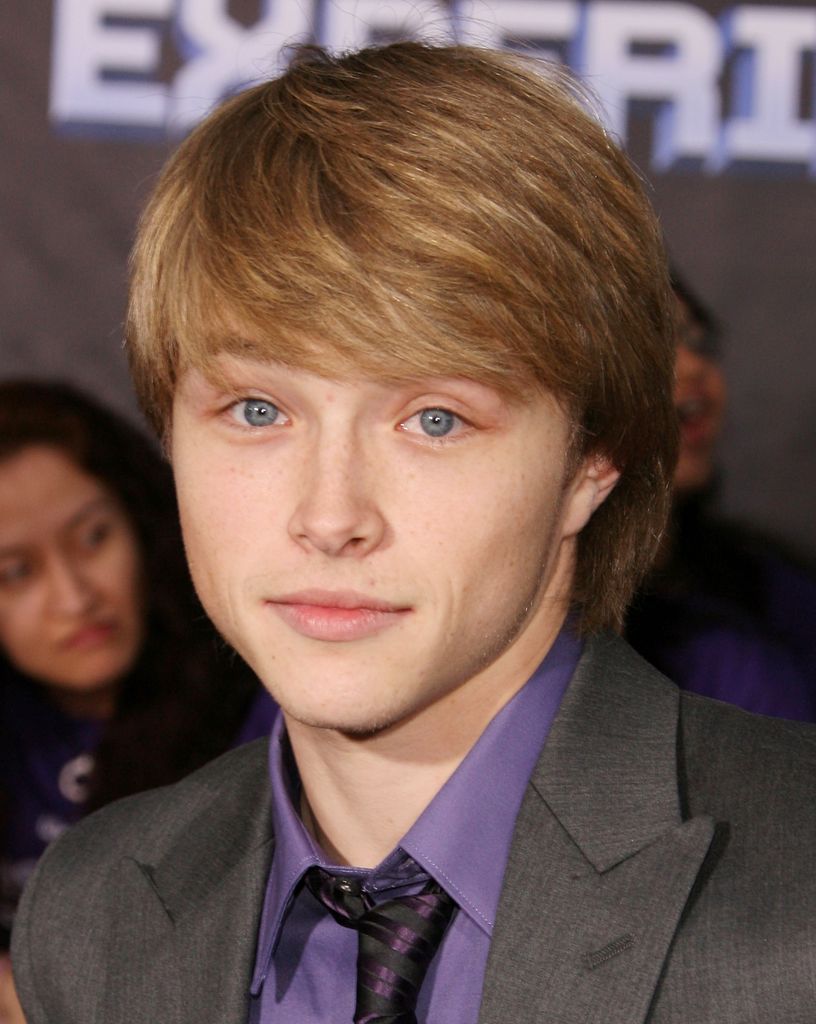 Sterling Knight dans une veste noire avec une chemise violette et une cravate lors de la première de Jonas Brothers The 3D Concert Experience.