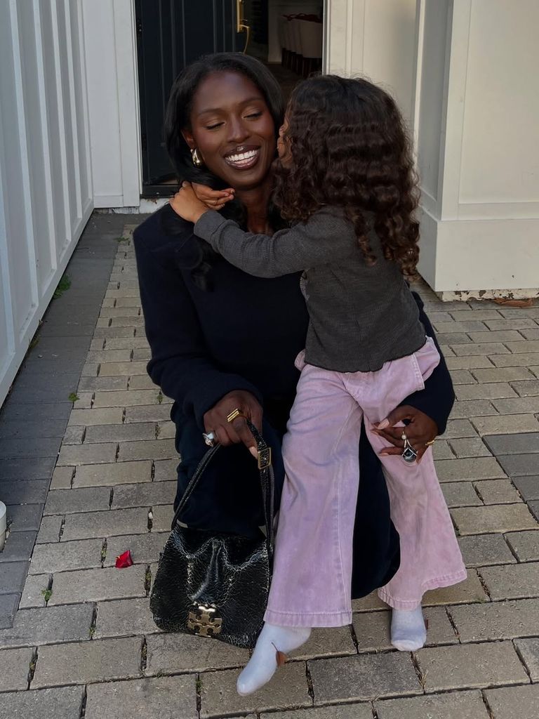 Photo of Jodie kneeling down next to her daughter in black coat