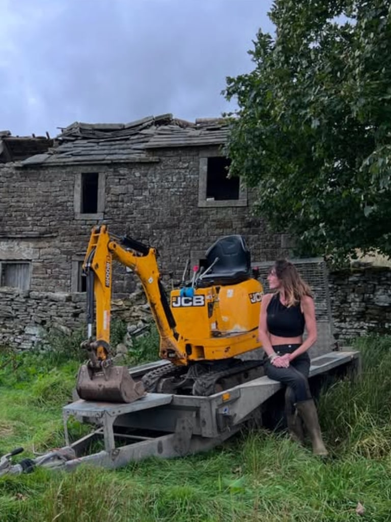 amanda owen on digger in jeans, top and wellington boots