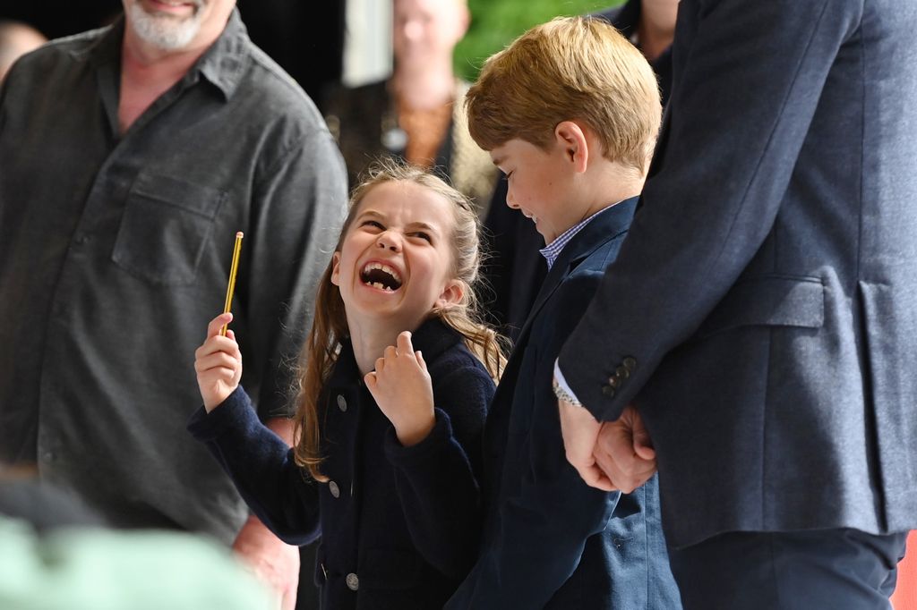 Princess Charlotte laughing alongside her brother Prince George during a royal visit to Cardiff