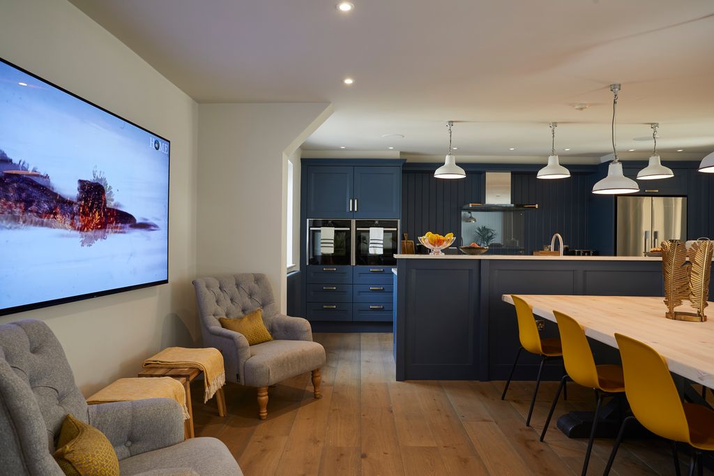 blue and yellow living room with large TV mounted on wall