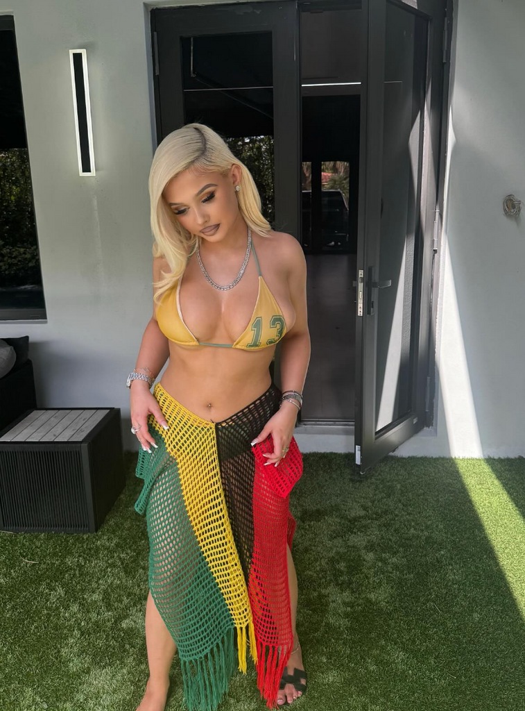 Photo shared by Travis Barker's daughter Alabama on Instagram February 2024 in which she is posing in a yellow bikini paired with a green, yellow, black and red mesh cover up.