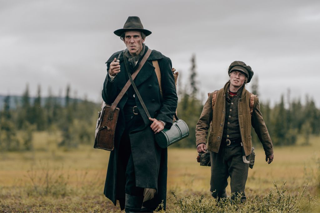 Two men walk in a field
