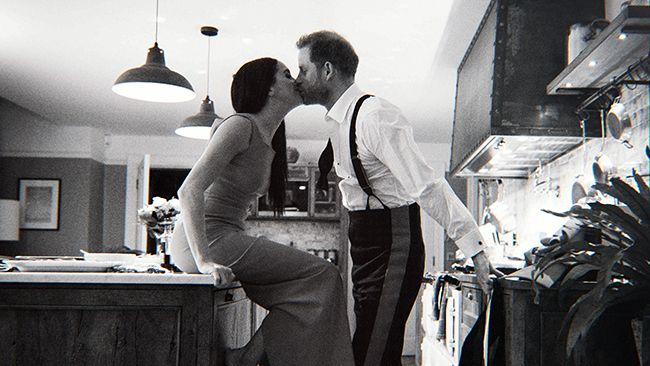 Prince Harry and Meghan Markle kissing inside their kitchen