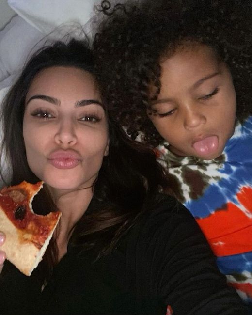 kim and one of her children tucking in to pizza
