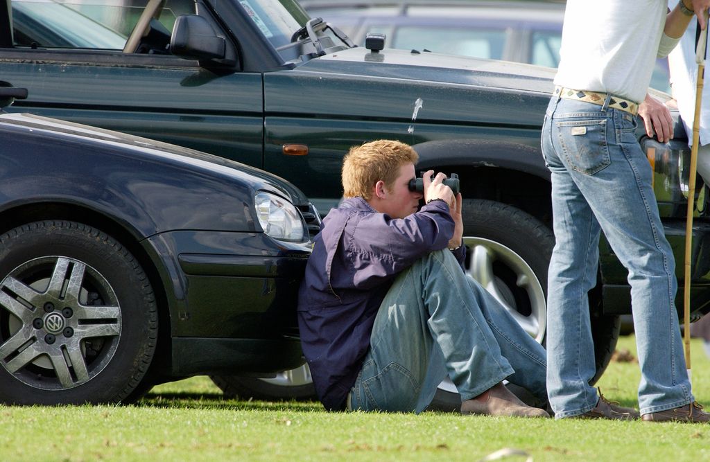 Prince Harry pictured with his trusty VW Golf while watching the action through binoculars at Cirencester Park Polo Club