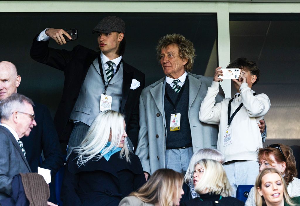 Alastair Stewart with Rod Stewart and Aiden Stewart at a football match; Alastair and Aiden are taking photos