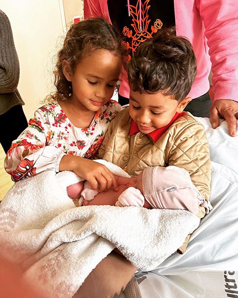 chrissy teigen daughter and son cuddling newborn sister