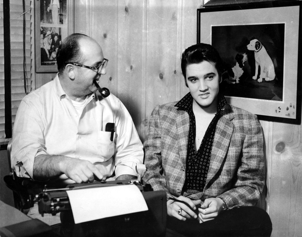Elvis Presley with his manager Colonel Tom Parker pose in front of a picture of the RCA Victor dog in circa 1957 in Memphis, Tennessee