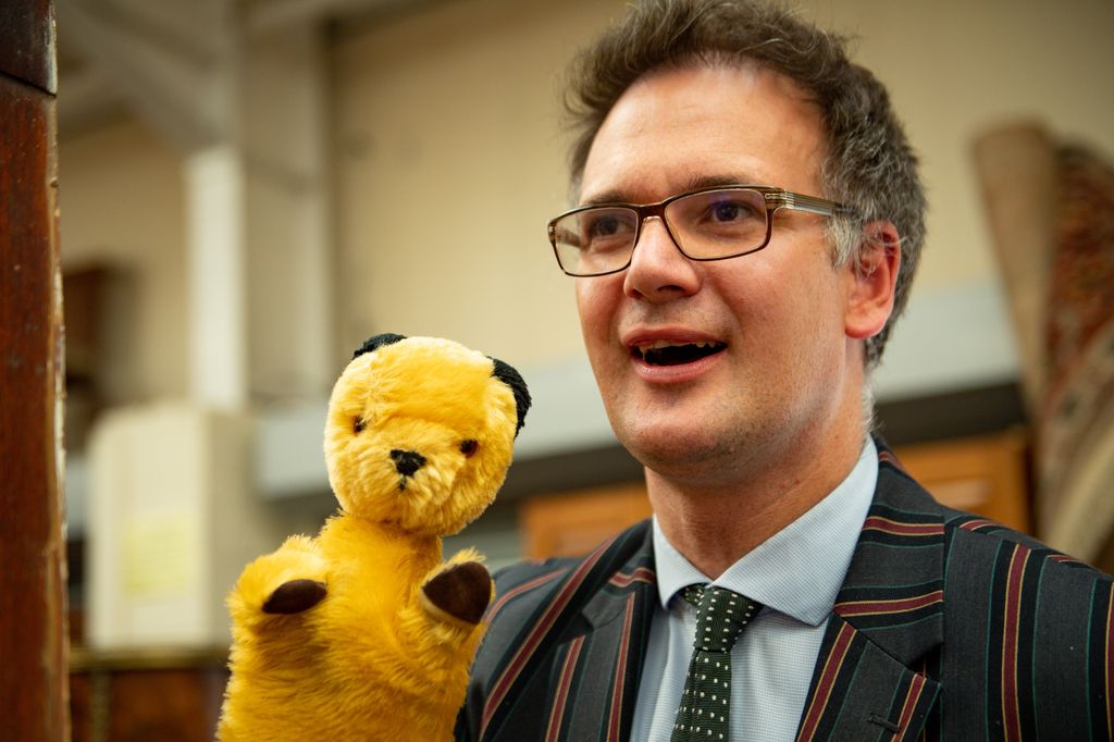 close-up of man in suit holding puppet