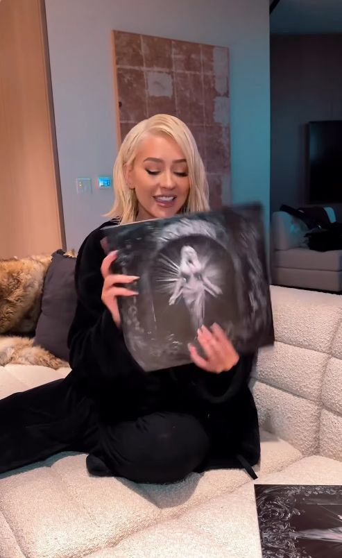 Christina Aguilera holding a vinyl record in black outfit